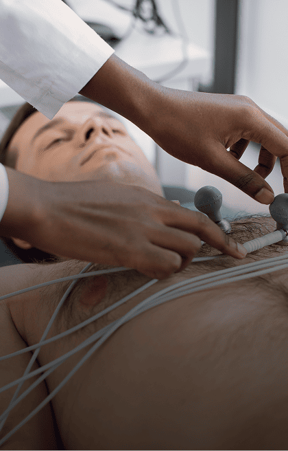 Médica realizando eletrocardiograma em um paciente deitado